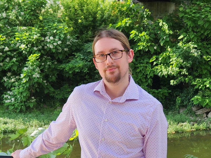 portrait of a suave and handsome man in front of a luscious river